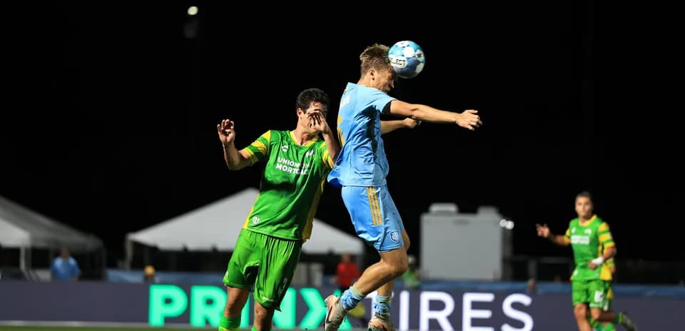 Player heading the ball during match