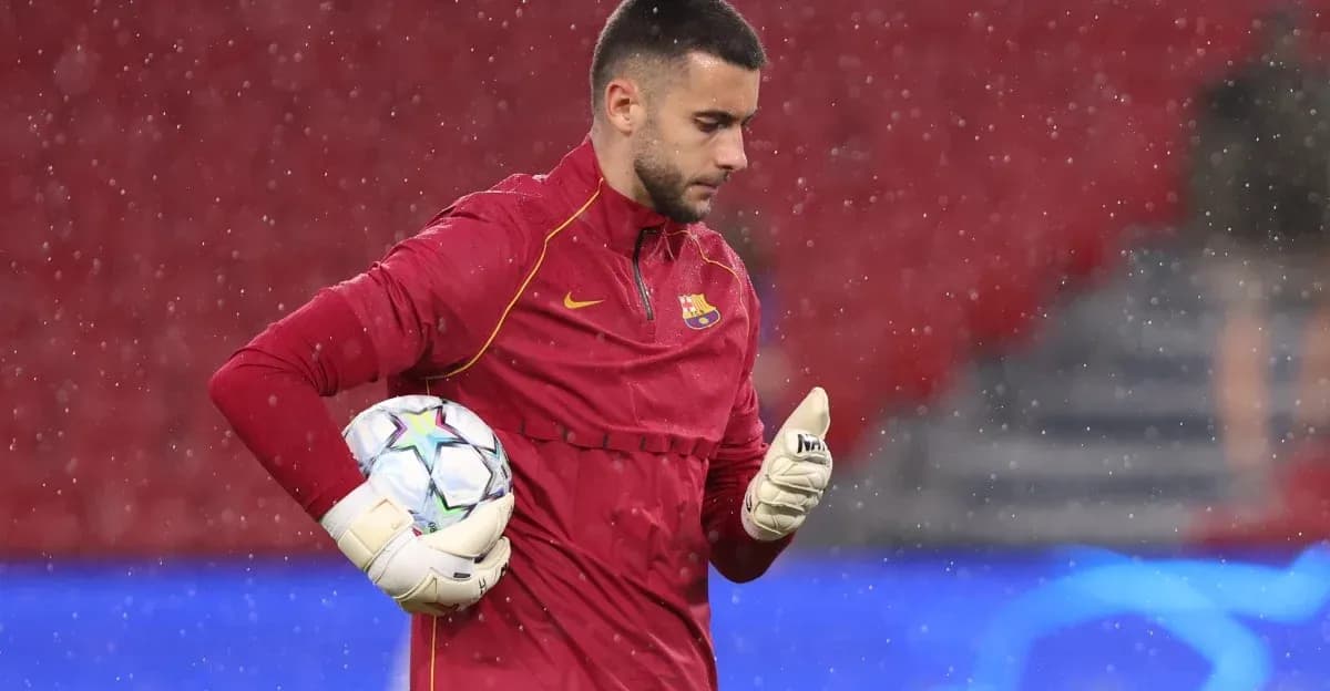 Goalkeeper in red jersey holding a soccer ball