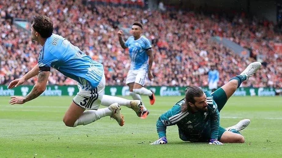 Player falling near goalkeeper during football match
