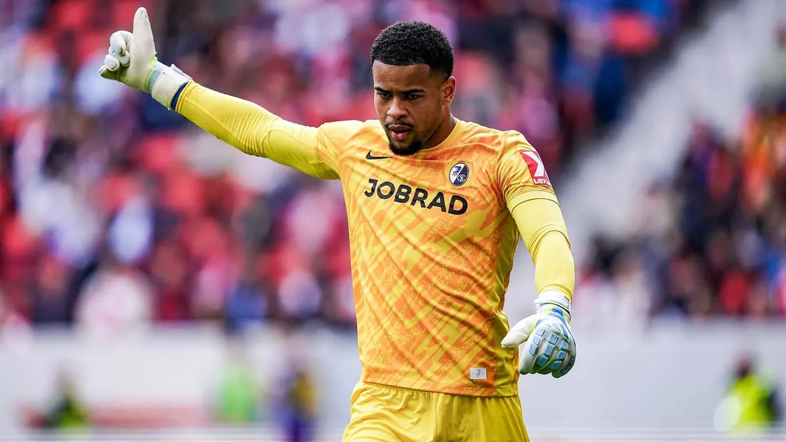 Goalkeeper in yellow jersey signaling during match