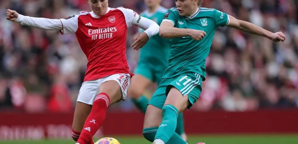 Arsenal player challenges Liverpool player for the ball