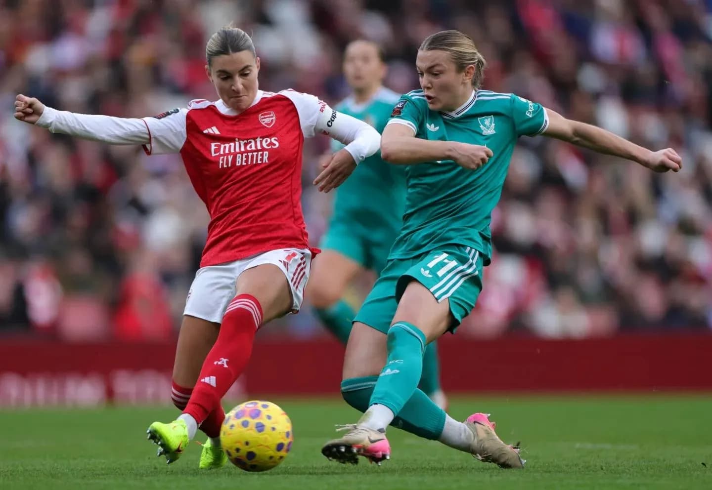 Arsenal player challenges Liverpool player for the ball