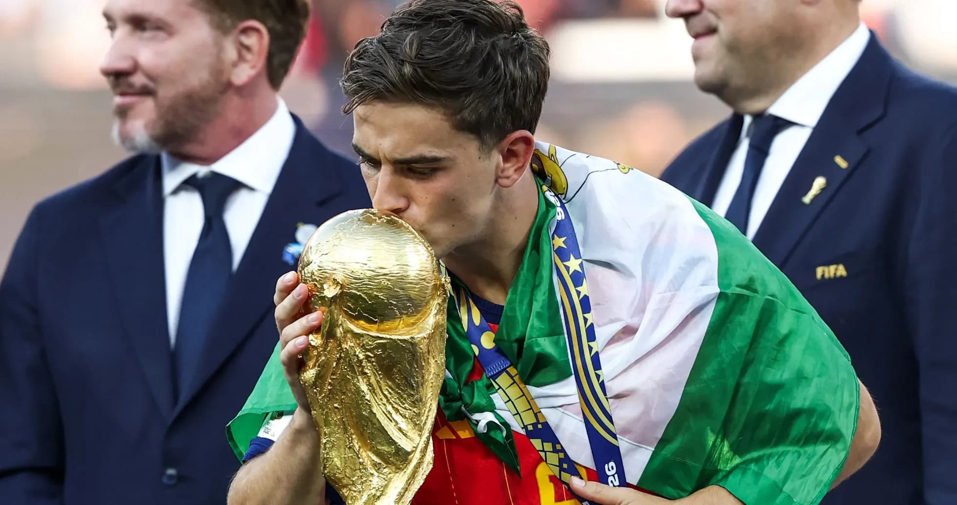 Player kissing World Cup trophy with national flag
