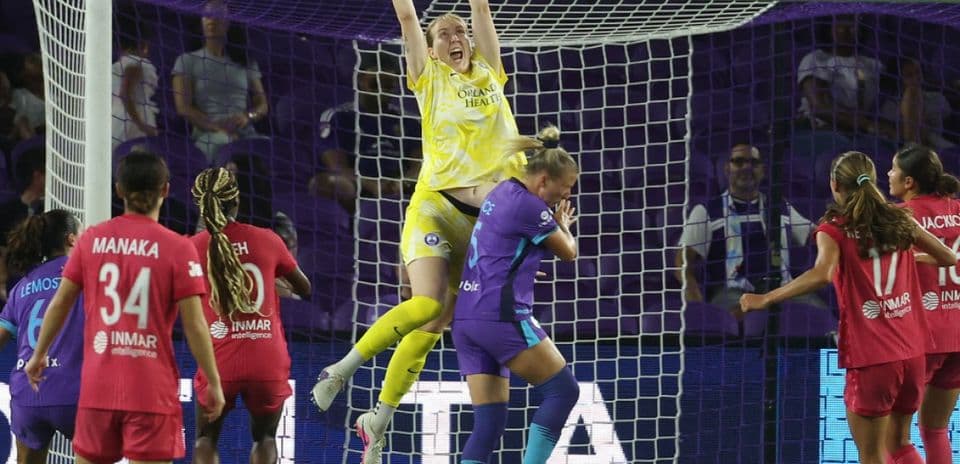 Goalkeeper jumping to catch the ball during match