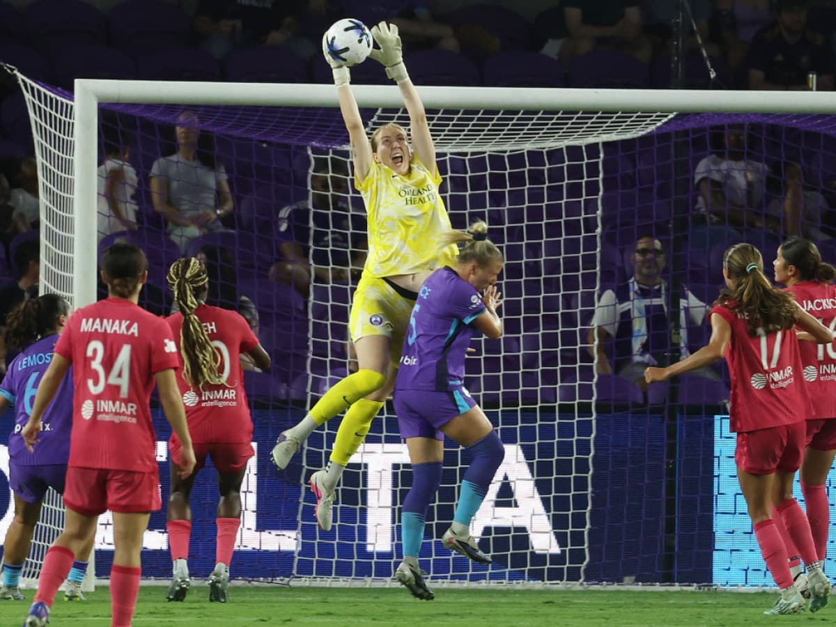 Goalkeeper jumping to catch the ball during match
