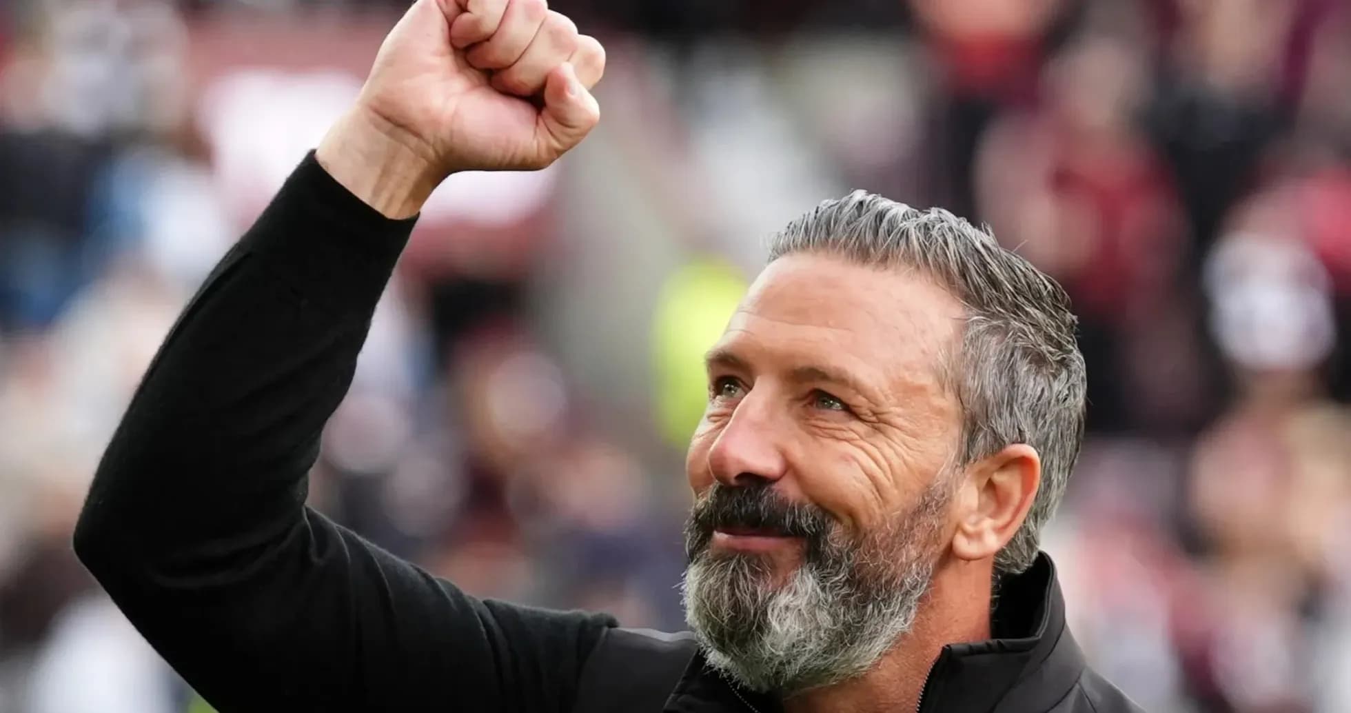 Coach celebrating with raised fist in stadium