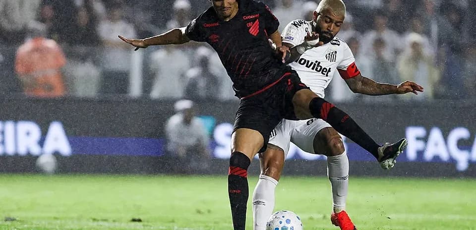Two players battling for the ball during rain