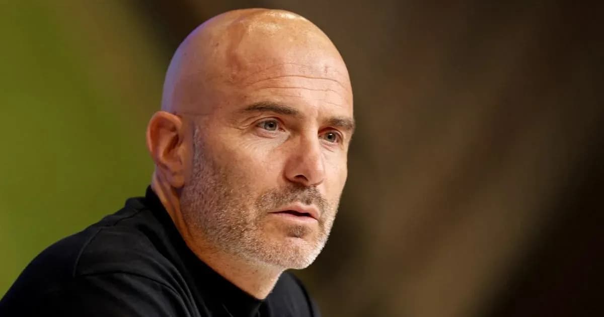 Coach speaking at a press conference table