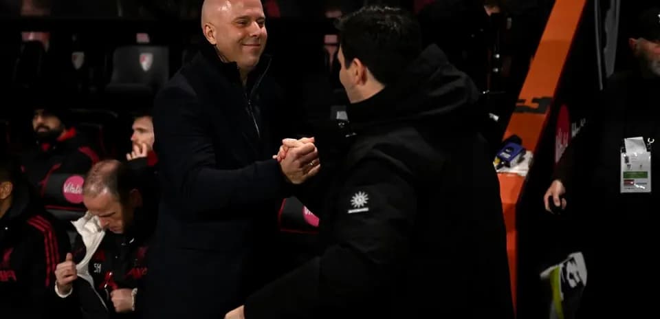 Two coaches shaking hands on the sidelines