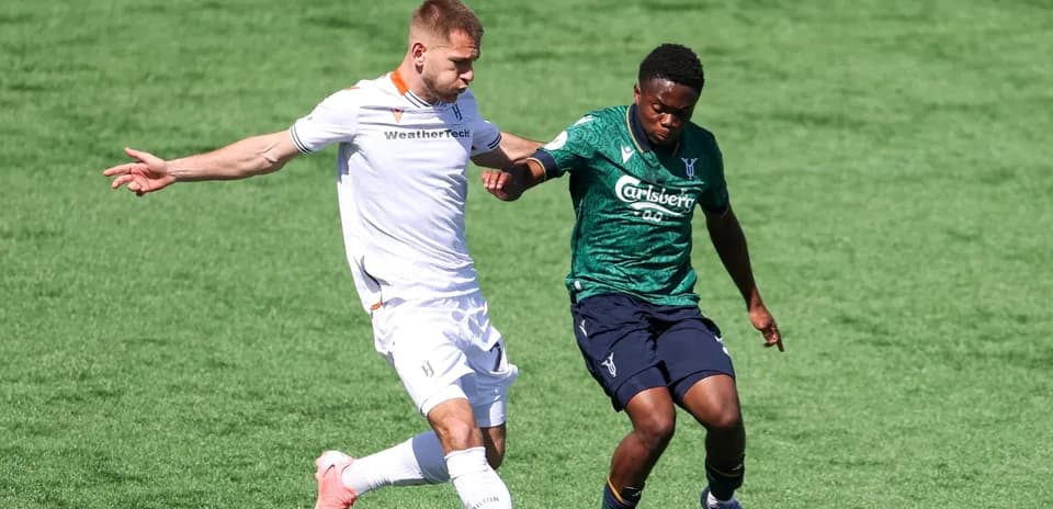Two players competing for the ball in football match