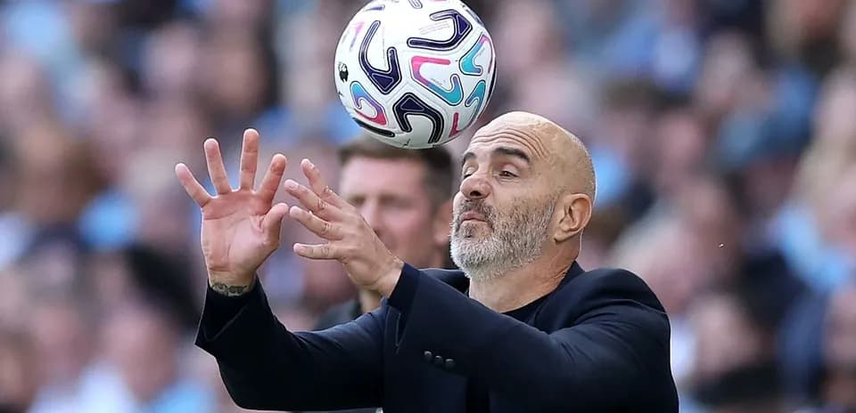 Coach attempting to catch a football during match