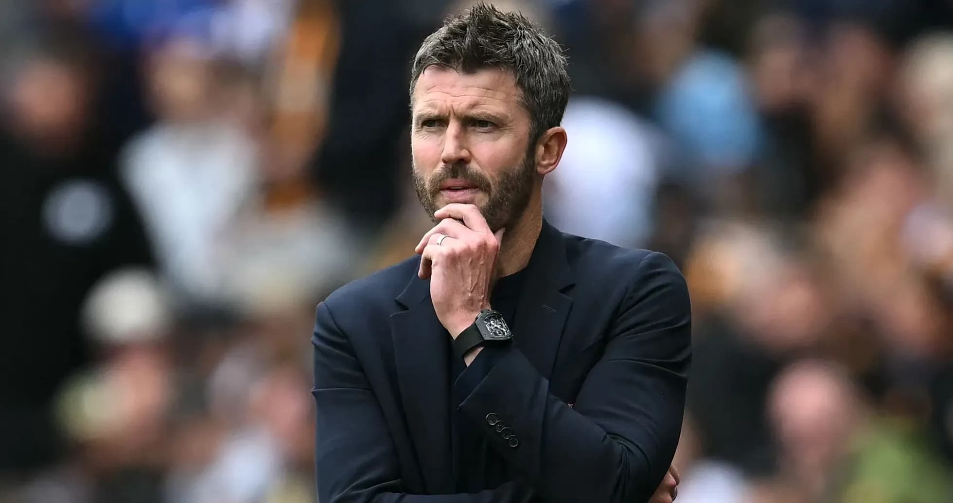 Coach observing the match with a thoughtful expression