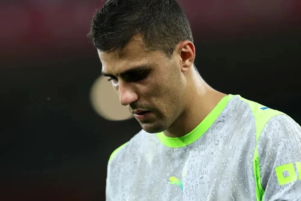 Goalkeeper in training kit looking down