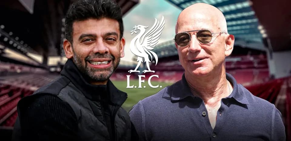 Two men smiling at Anfield stadium backdrop