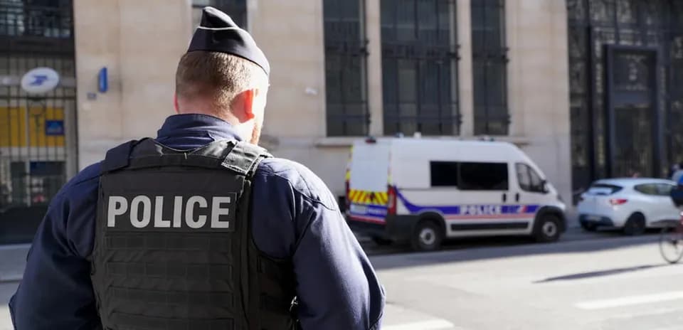 Police officer standing near police van on street