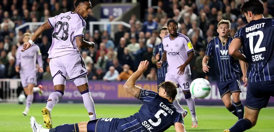 Player shooting on goal while defender falls