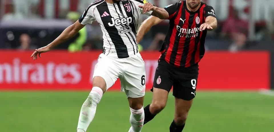 Juventus player tackling AC Milan opponent