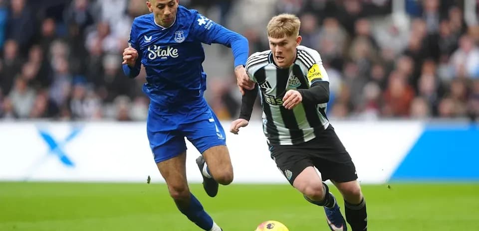 Newcastle player sprinting with ball, Everton defender close