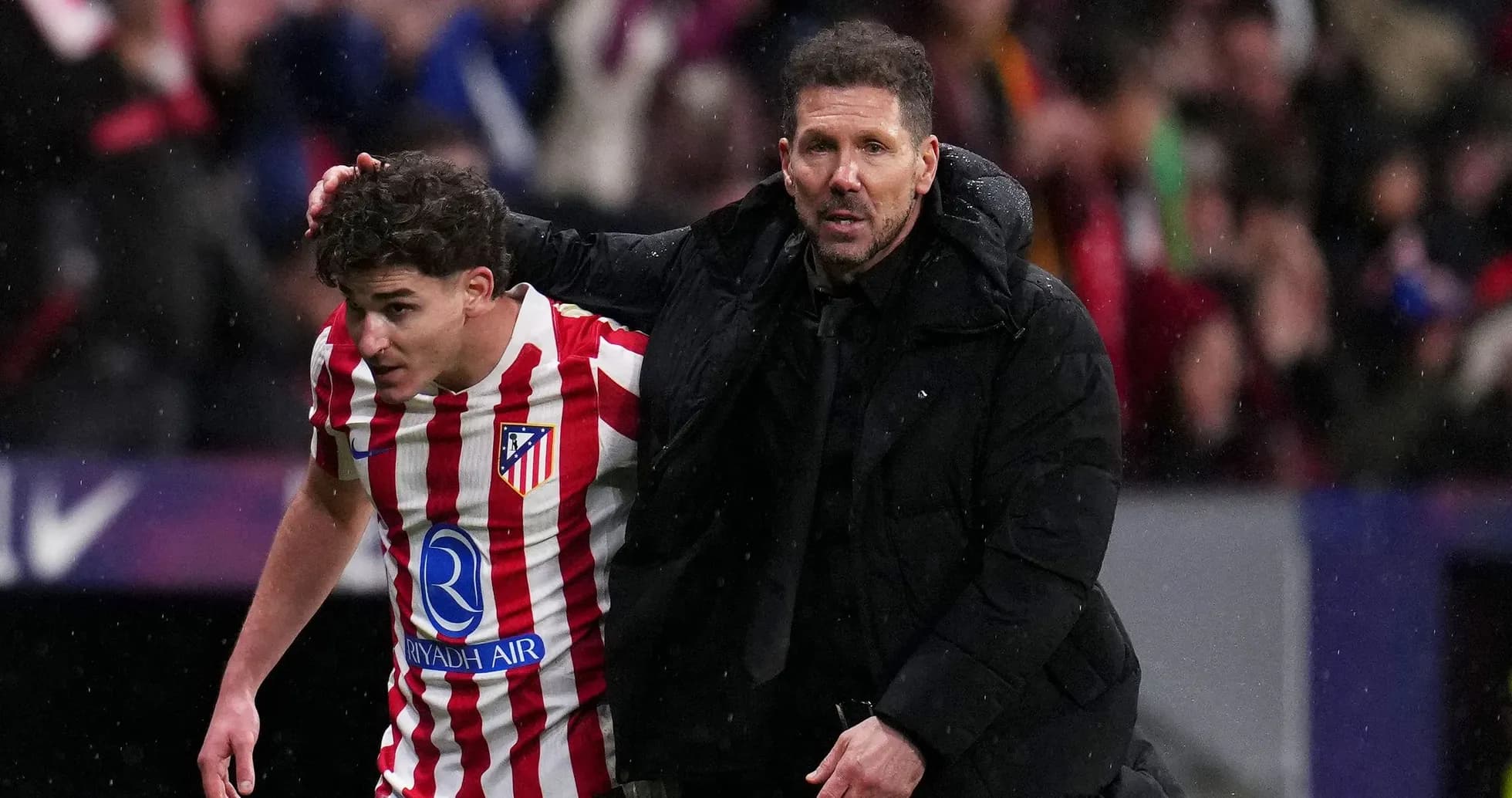 Atletico Madrid coach assisting player off field