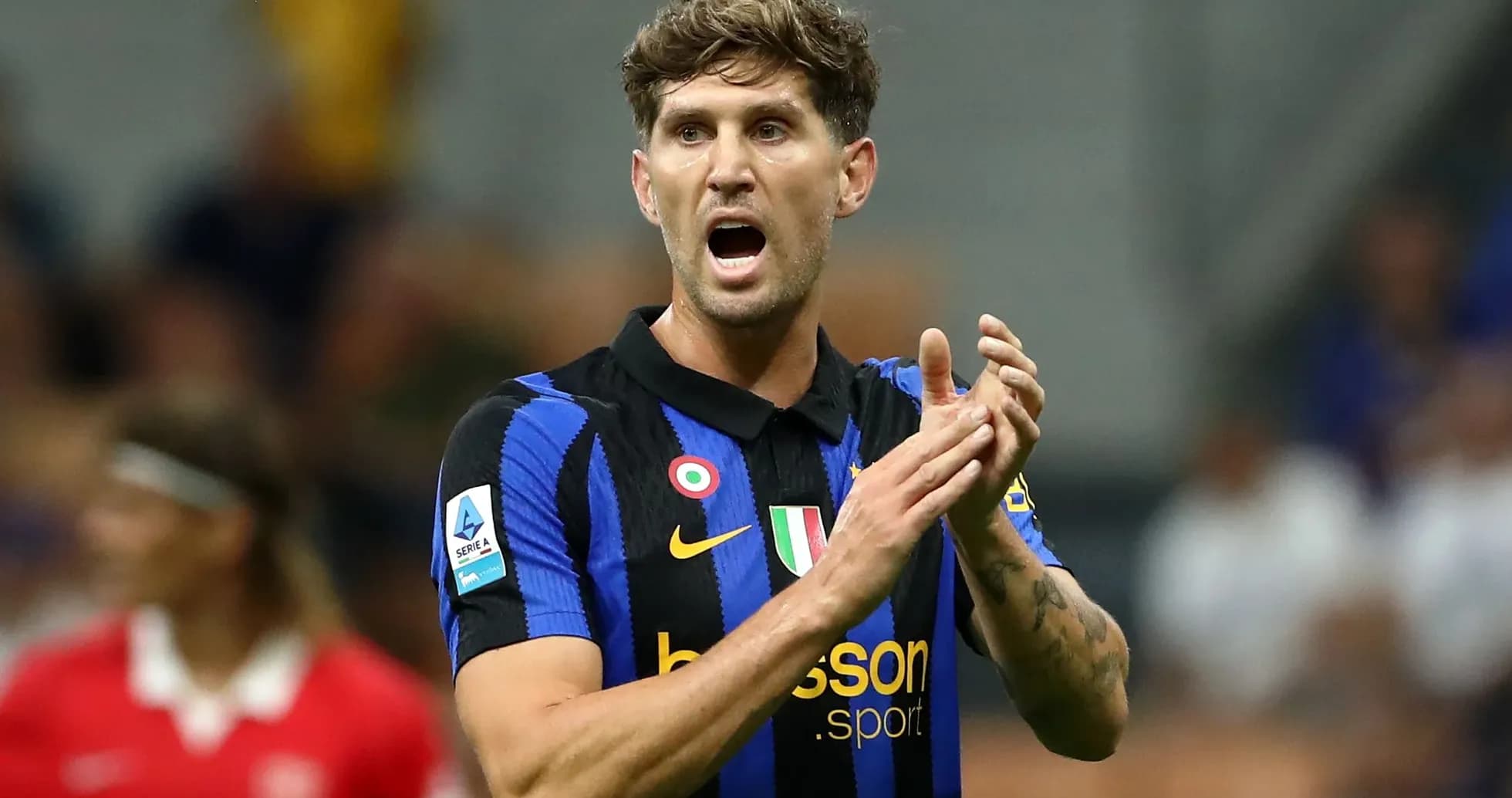 Player in blue and black jersey clapping during match