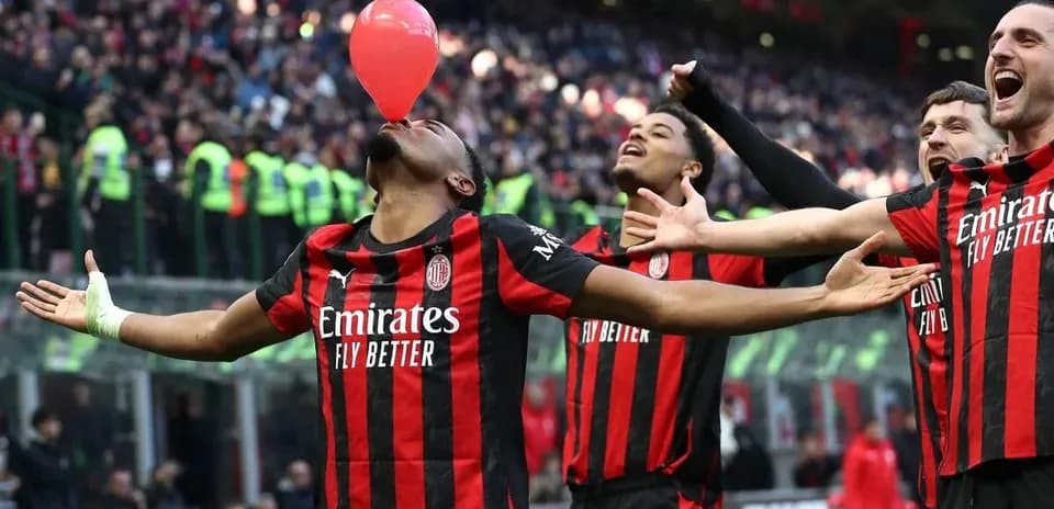 AC Milan players celebrating with a balloon during match