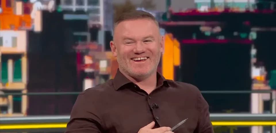 Sports analyst smiling during a television broadcast