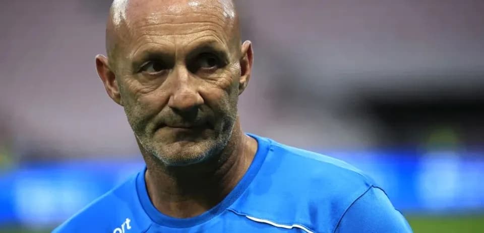 Coach in blue training gear on field
