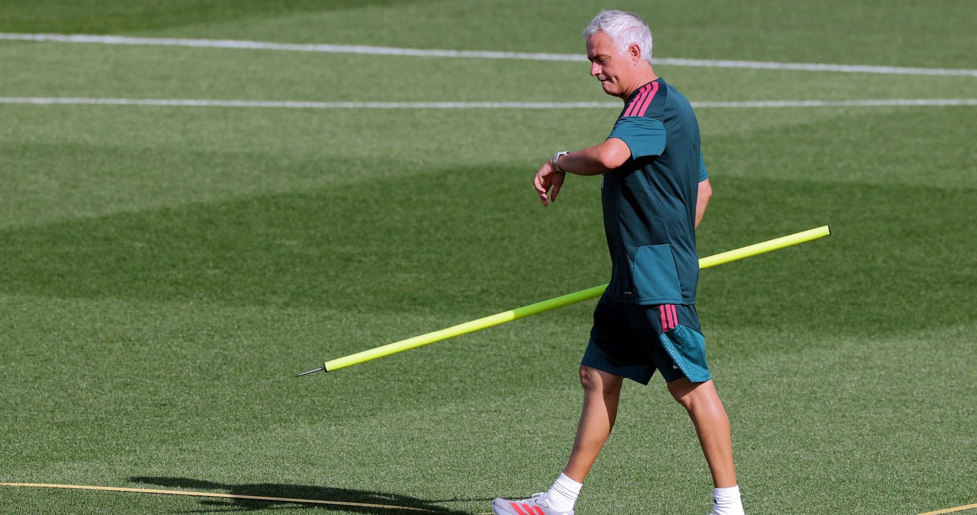 Coach walking with training equipment on the field