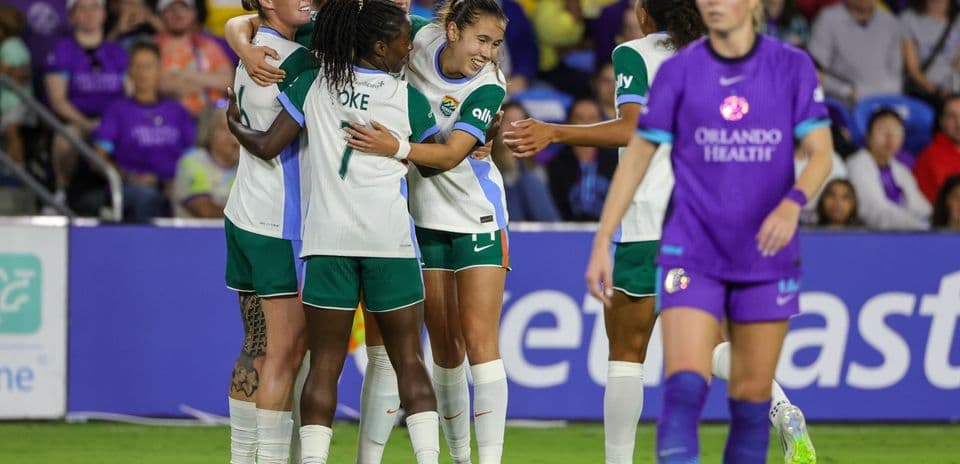 Players celebrating a goal during NWSL match