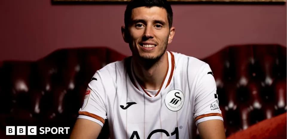Player wearing Swansea City jersey, smiling at camera