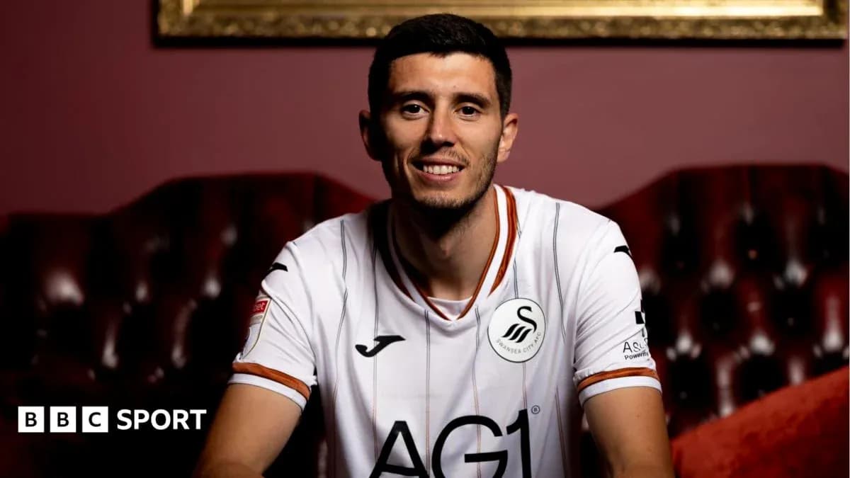 Player wearing Swansea City jersey, smiling at camera