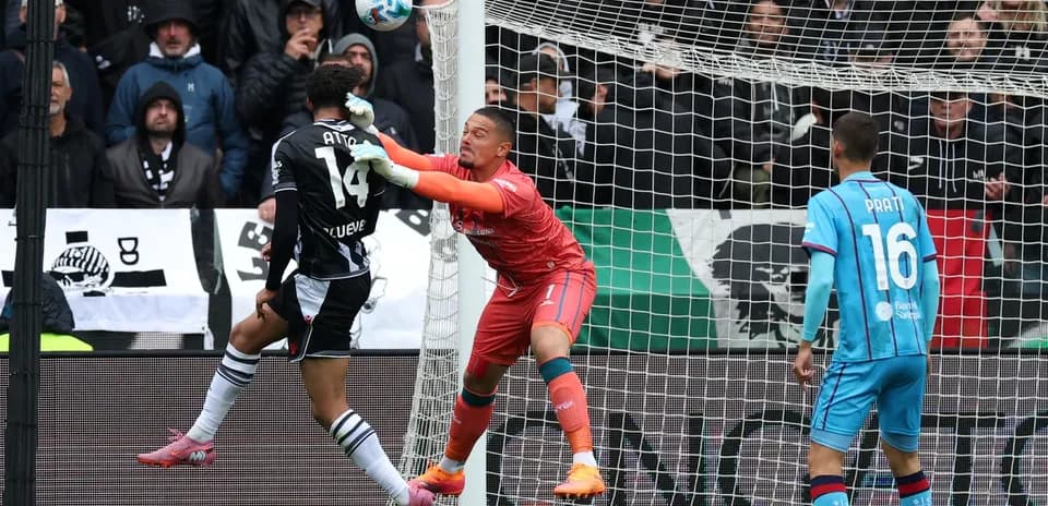 Goalkeeper challenges striker during Cagliari match