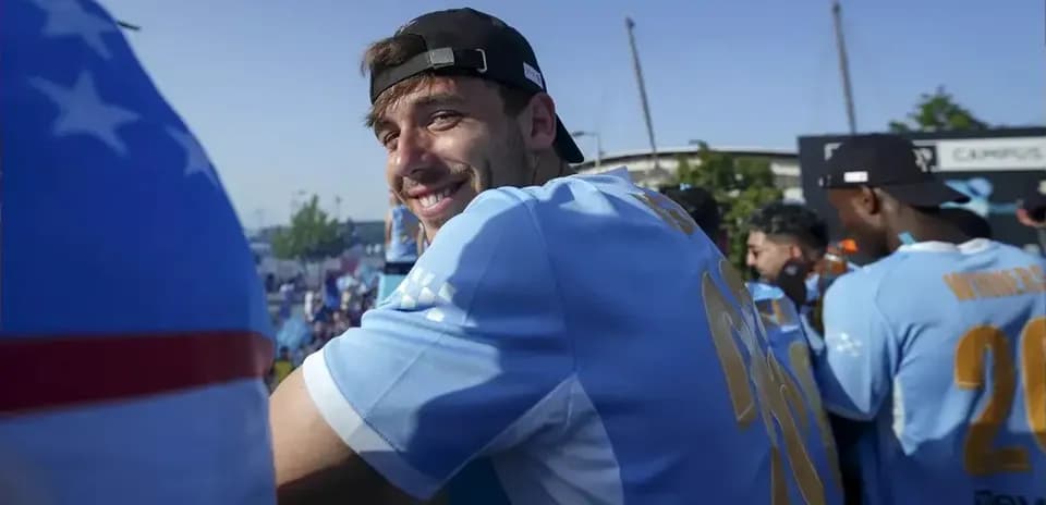 Player smiling during celebratory event in team jersey