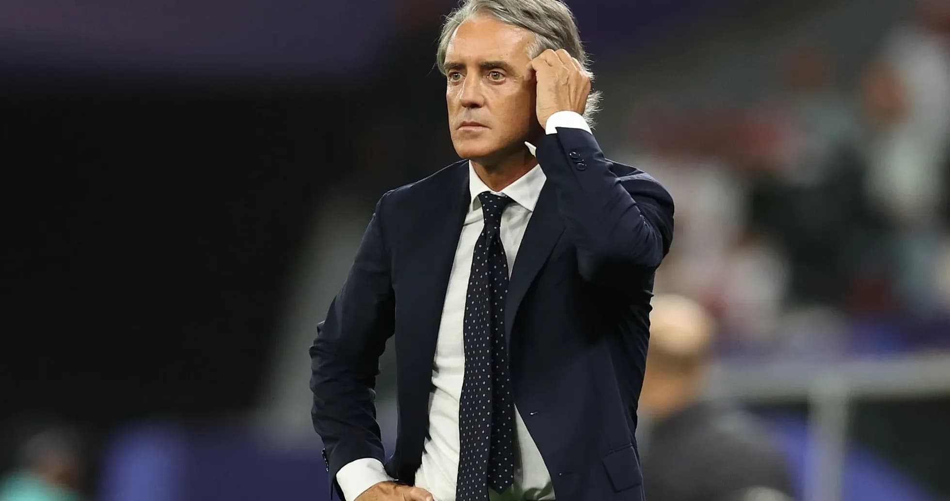 Manager observing the match with a thoughtful expression