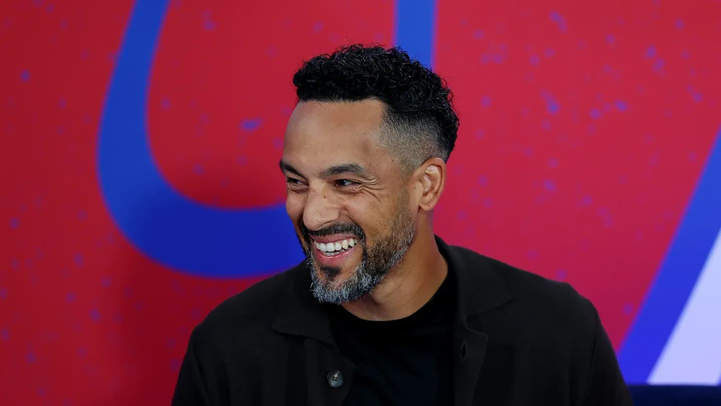 Man smiling in front of colorful background