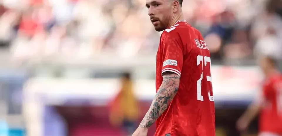 Player in red jersey on football pitch during match