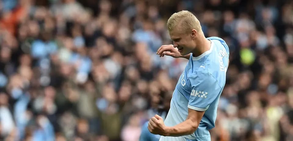 Player celebrating a goal in front of fans