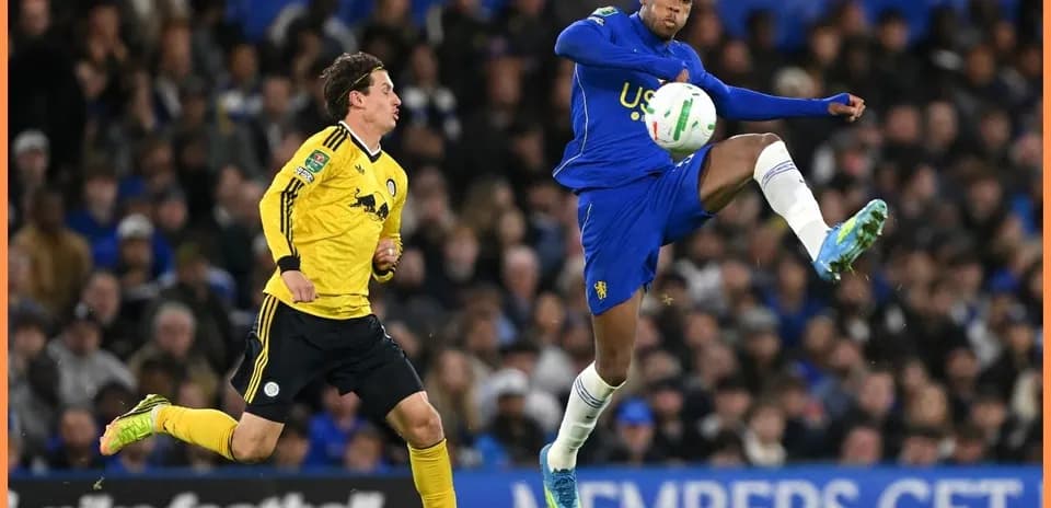 Player kicking ball while opponent defends during match