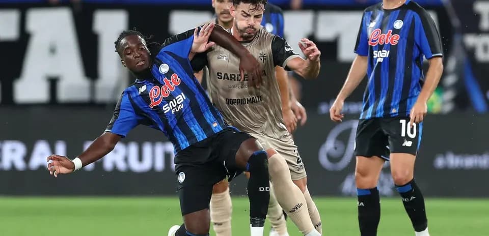 Atalanta player tackling Cagliari opponent in match