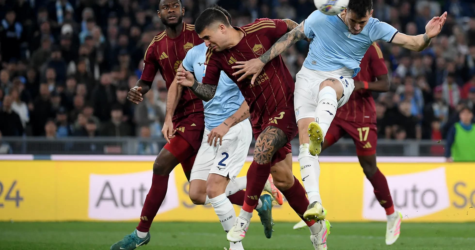 AS Roma players challenging Lazio forward during match