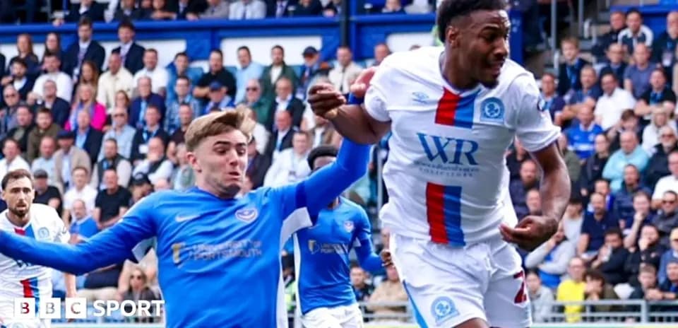Player in blue shirt attempting to tackle opponent