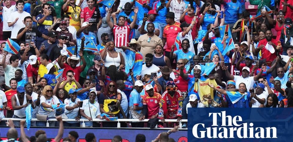 Crowd of fans waving flags at sporting event