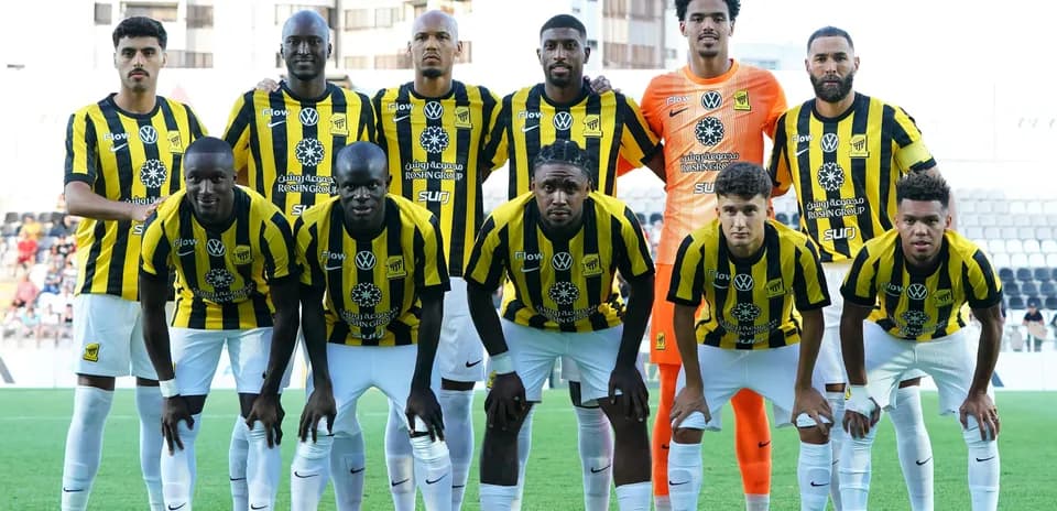 Football team in black and yellow kits posing for photo