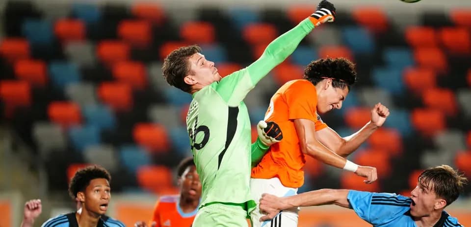 Goalkeeper punches the ball during match action