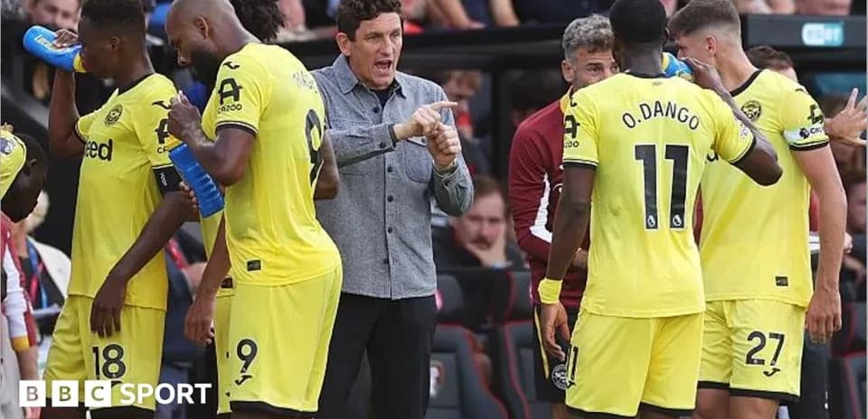 Manager instructing players on the sidelines during match