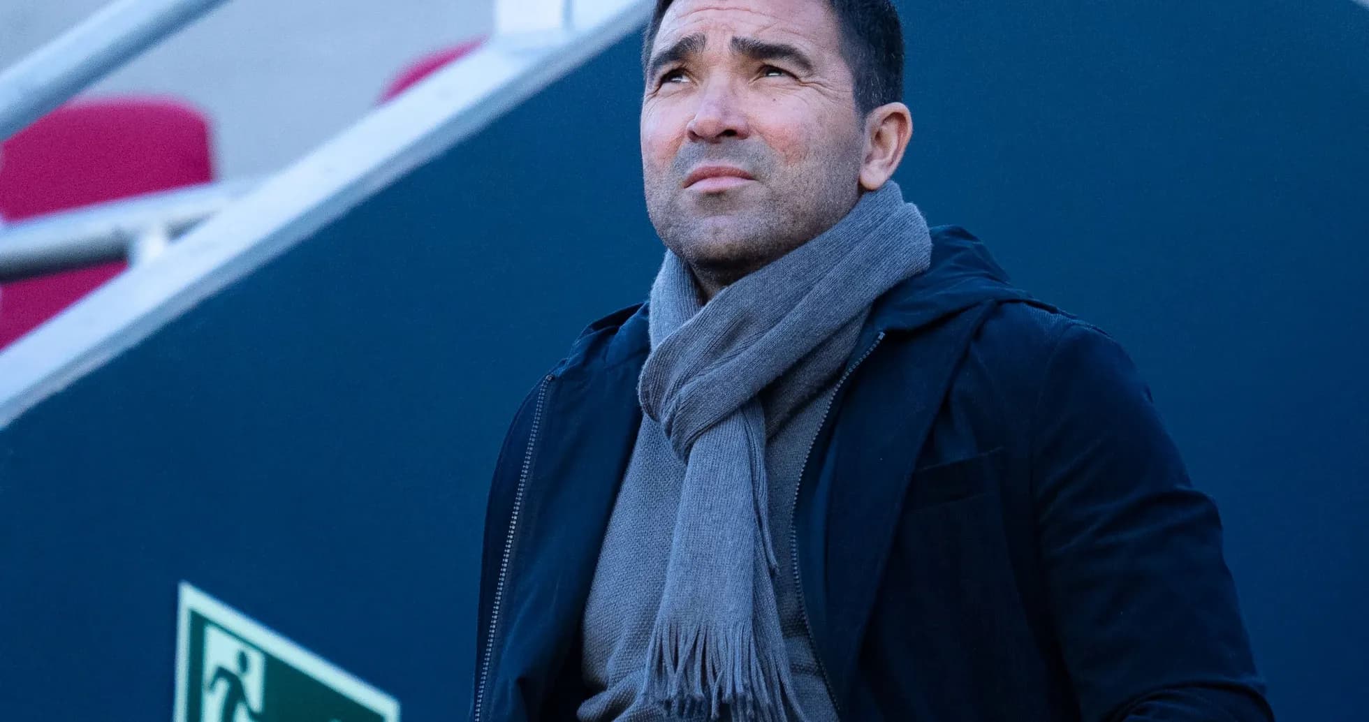 Man in a black jacket and gray scarf looking up