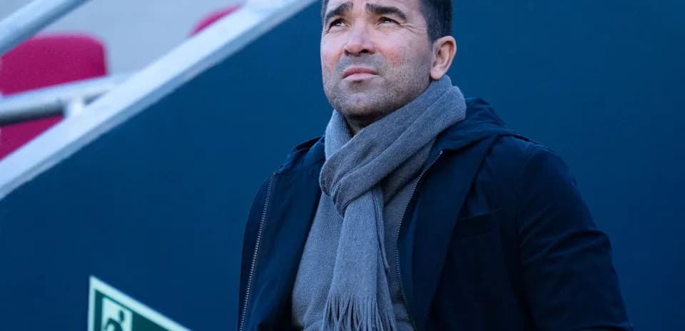 Man in a black jacket and gray scarf looking up