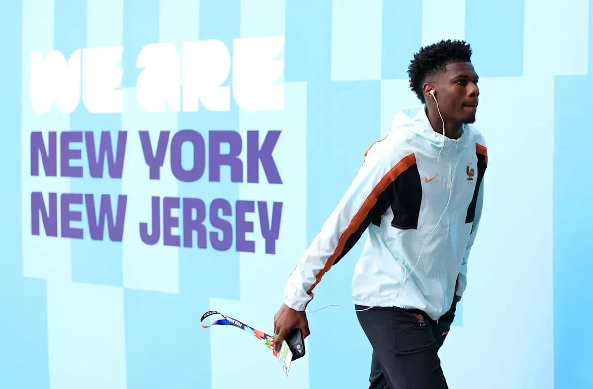 Player walking with headphones near promotional wall