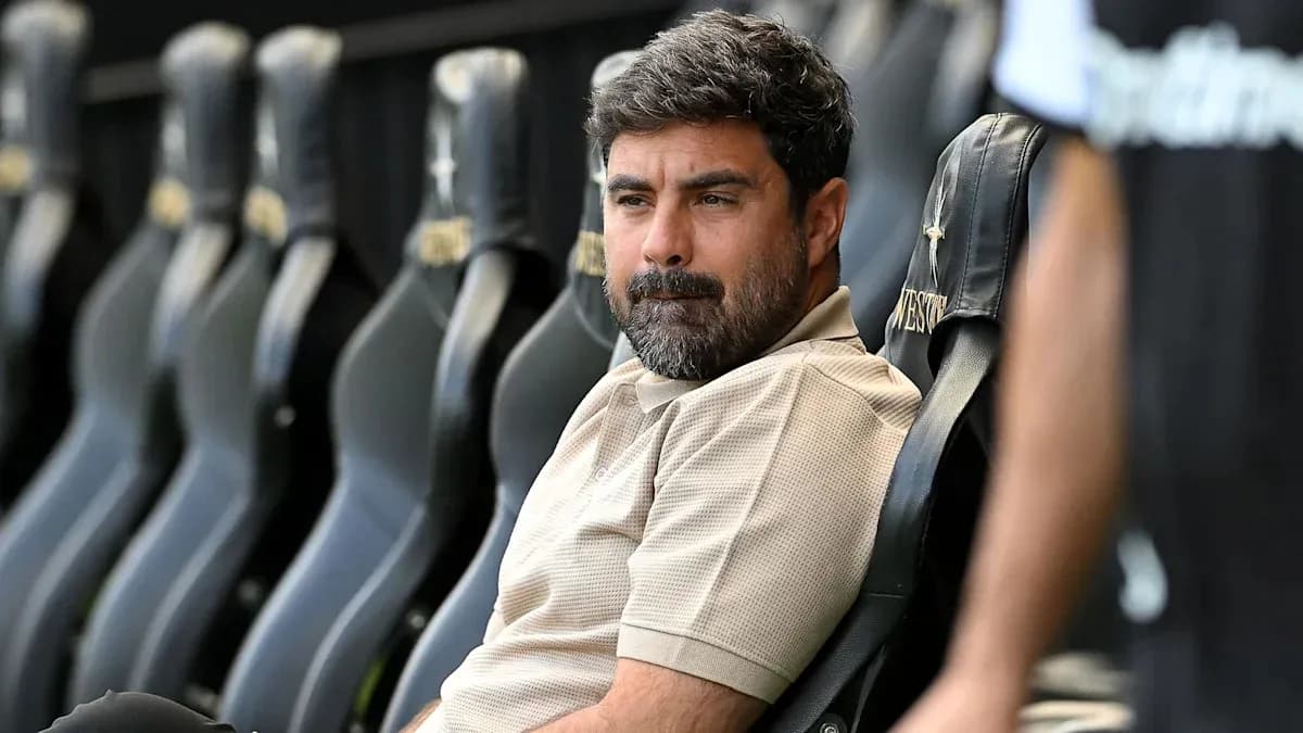 Coach seated on bench during match preparation