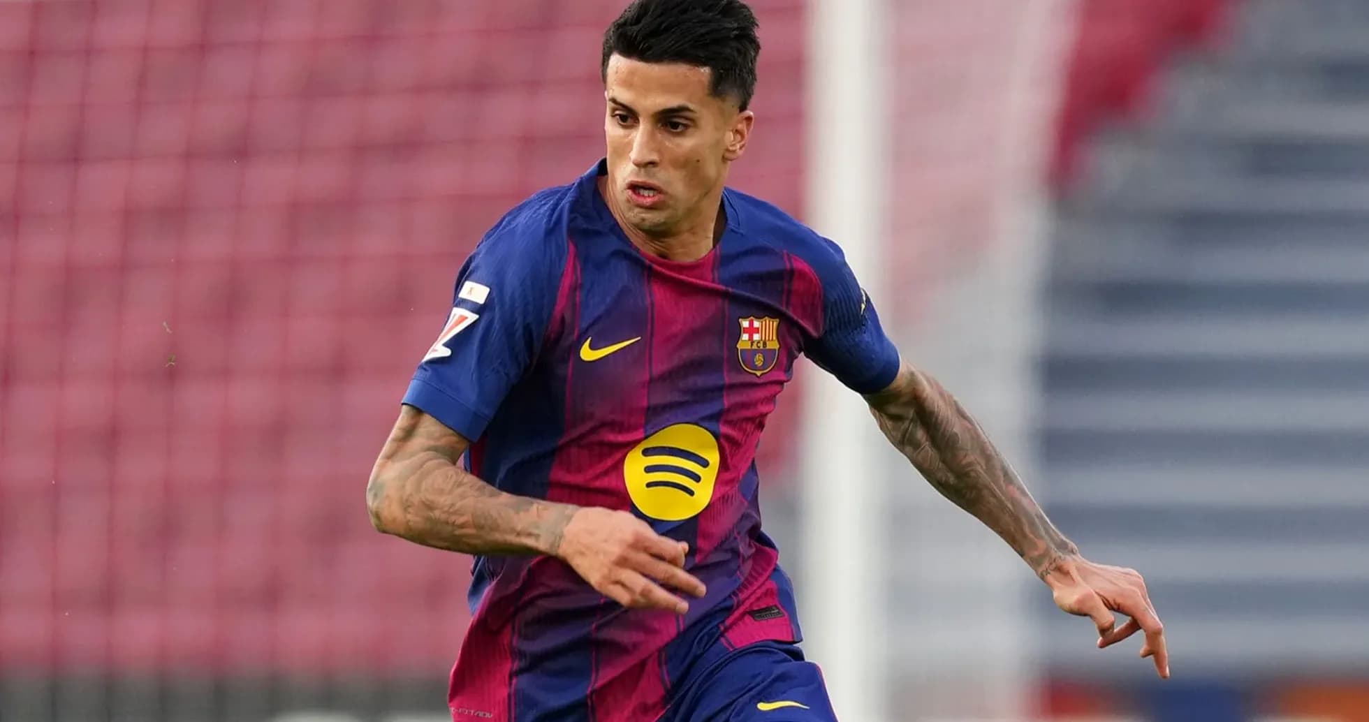Player in FC Barcelona jersey running on the field
